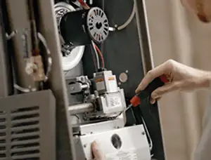 Furnace repair technician inspecting internal components and wiring in Brandon, FL